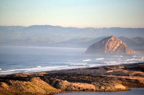 Morro Rock and the surfline beyond the dunes.